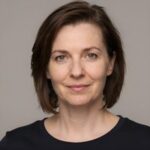 Профессиональный портрет уверенного российского бизнесмена с дружелюбным взглядом на размытом нейтральном фоне